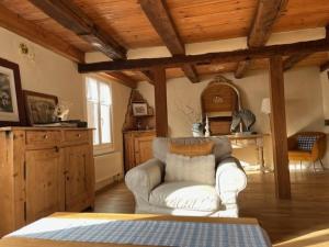 a living room with a white couch and a wooden ceiling at Gîte aux charmes d'Antan in Weinbourg