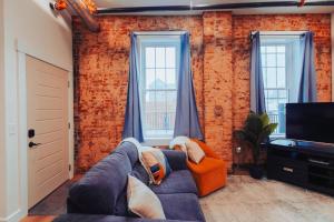 a living room with a blue couch and a tv at American Hall - Young Suite in Millersburg
