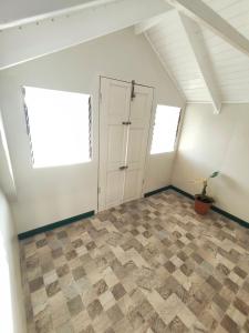 a attic room with a door and a tiled floor at Mage B&B 1 in Roseau