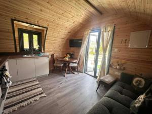 a living room with a couch and a table in a cabin at Casa Leandro glamping wooden tiny house in Lachi
