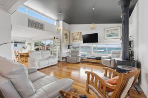 a living room with white furniture and a fireplace at Beachfront Beauty Bellerive in Bellerive