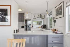a kitchen with a large white counter top with a chair at Beachfront Beauty Bellerive in Bellerive