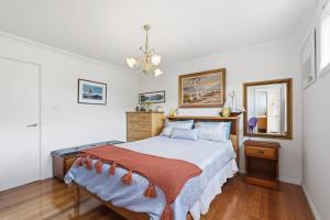 a bedroom with a bed and a mirror at Beachfront Beauty Bellerive in Bellerive