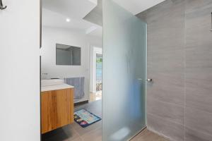 a bathroom with a shower and a sink at Beachfront Beauty Bellerive in Bellerive +31 photos