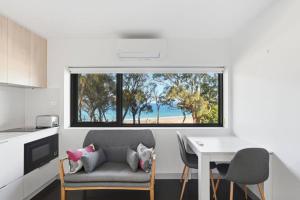a kitchen with a couch and a table and a window at Modern Beachside Studio in Kingston Beach