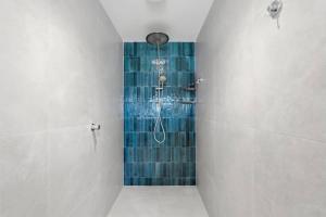a bathroom with a shower with blue tiles at Modern Beachside Studio in Kingston Beach +15 photos