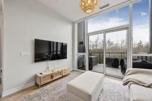 ein Wohnzimmer mit Fernseher und großem Fenster in der Unterkunft Lake Simcoe Stays - Friday Harbour's Official Rental Program - Aspen Suite in Innisfil