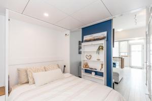 ein Schlafzimmer mit einem weißen Bett und einer blauen Akzentwand in der Unterkunft Lake Simcoe Stays - Friday Harbour's Official Rental Program - Beech Suite in Innisfil