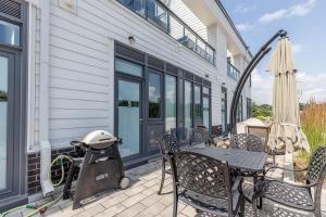 eine Terrasse mit Tisch, Stühlen und Sonnenschirm in der Unterkunft Lake Simcoe Stays - Friday Harbour's Official Rental Program - Beech Suite in Innisfil