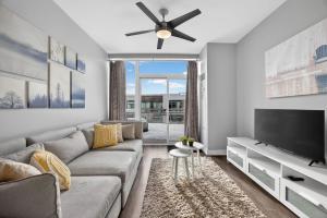 a living room with a couch and a flat screen tv at Lake Simcoe Stays - Friday Harbour's Official Rental Program - Scyamore Suite in Innisfil