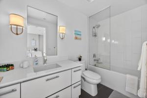 a white bathroom with a sink toilet and a mirror at Lake Simcoe Stays - Friday Harbour's Official Rental Program - Scyamore Suite in Innisfil