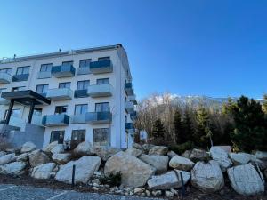 a building with a bunch of rocks in front of it at Apartmán Tatrya in Vysoké Tatry