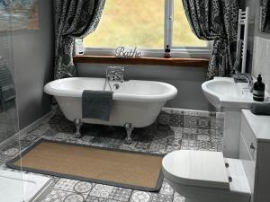 a bathroom with a tub and two sinks and a window at Millers Loft in Llanrwst +19 photos