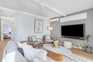 a living room with a couch and a tv at Coastal Waterfront Broadbeach Waters in Gold Coast