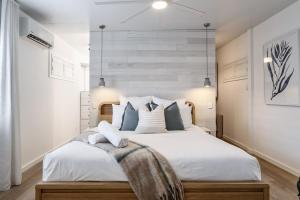 a bedroom with a large white bed with blue pillows at Coastal Waterfront Broadbeach Waters in Gold Coast +23 photos