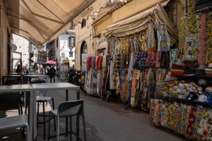 a street with a market with a bunch of shops at Casa Martù in Palermo