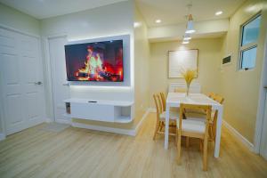 a dining room with a table and a tv on a wall at Silid Pahingahan at Forest Residences in Antipolo
