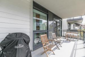 eine überdachte Veranda mit Stühlen und Tischen an einem Haus in der Unterkunft Lake Simcoe Stays - Friday Harbour's Official Rental Program - Tamarack Suite in Innisfil
