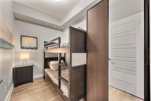 ein Schlafzimmer mit Etagenbett und Kleiderschrank in der Unterkunft Lake Simcoe Stays - Friday Harbour's Official Rental Program - Walnut Suite in Innisfil