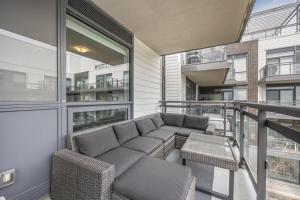 eine Veranda mit Sofa und Stühlen auf einem Balkon in der Unterkunft Lake Simcoe Stays - Friday Harbour's Official Rental Program - Walnut Suite in Innisfil + 1 Foto