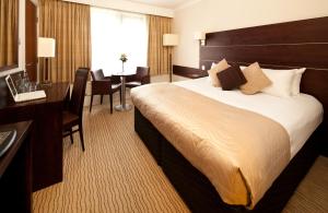 a hotel room with a bed and a desk at Mercure Bradford, Bankfield Hotel in Bradford