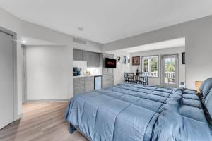 a bedroom with a large blue bed and a kitchen at Lux Studio in Horseshoe Valley in Shanty Bay