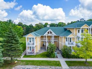 a large yellow house with a green roof at Lux Studio in Horseshoe Valley in Shanty Bay