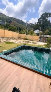 a swimming pool with blue tiles in a backyard at Baan kratay in Chaloklum