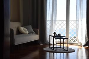 a living room with a couch and a table in front of a window at thalore room e apartments in Amantea