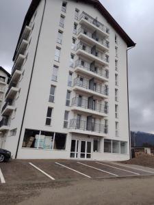 a large white apartment building with a parking lot at Panorama Loft in Gura Humorului