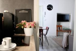 a living room with a refrigerator and a table with flowers at Casa Flavia-Comfort e relax nel cuore di Ariccia in Ariccia