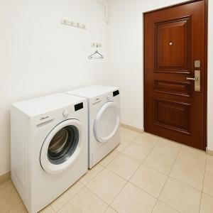 a washer and dryer in a room with a door at Nicolle Prestige Apartment in Piteşti