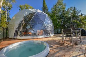 a igloo tent on a deck with a hot tub at Bel Air Tremblant Hotel - Dômes & Chalets in Mont-Tremblant