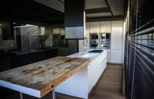 a kitchen with white cabinets and a wooden counter top at Bilor Luxury Holidays in Subbiano