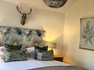 a bedroom with a bed with a deer head on the wall at Scarborough Hill Country Inn in North Walsham