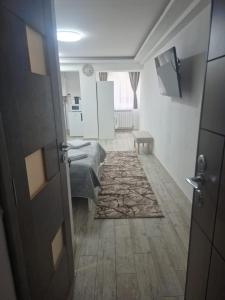 a room with a bed and a table and a door at Central Studio in Târgu Secuiesc