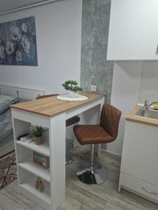 a small kitchen with a table and a chair at Central Studio in Târgu Secuiesc