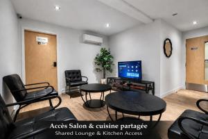a waiting room with chairs and tables and a tv at Room with 2 Queen-Size Beds Downtown Quebec in Quebec City +14 photos