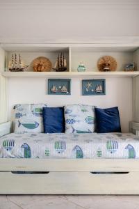 a bed in a room with blue pillows and shelves at Dunas de vilamoura in Quarteira +124 photos