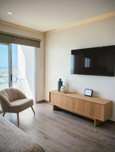 a living room with a large television on the wall at Sanmarcos in Playa Paraiso