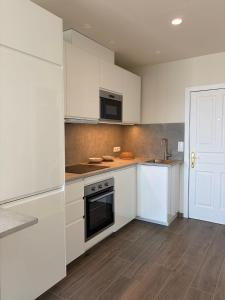 a kitchen with white cabinets and a stove top oven at Sanmarcos in Playa Paraiso