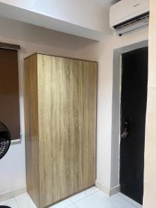 a wooden cabinet in a room with a wall at Studio Apartment with Rooftop & Pool Access in Lagos