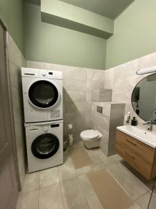 a bathroom with a washing machine and a toilet at Jóbarát Apartman in Győr +10 photos