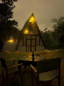 a house with a table and chairs in front of it at Alpine Heights in Kumburuteniwela
