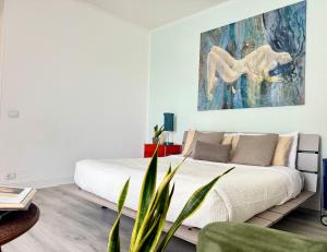 a bedroom with a bed and a painting on the wall at Casa Flavia-Comfort e relax nel cuore di Ariccia in Ariccia