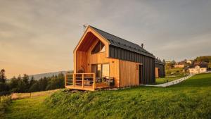 a small wooden house on a grassy field at Olecka Village Resort & Spa in Jaworzynka