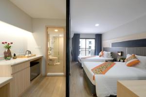 a hotel room with two beds and a bathroom at O2 Grand Suvarnabhumi Airport - Free Scheduled Shuttle from Hotel to Suvarnabhumi Airport in Bang Phli