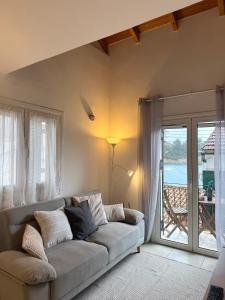 a living room with a couch and a balcony at Ntina Apartment - Loggos, Paxos in Longós