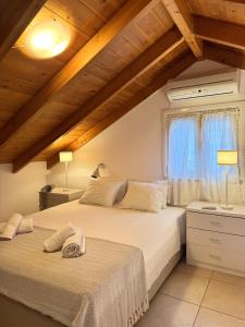 two beds in a bedroom with wooden ceilings at Ntina Apartment - Loggos, Paxos in Longós