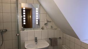 a bathroom with a sink and a mirror at Löns Hotel Garni in Garbsen